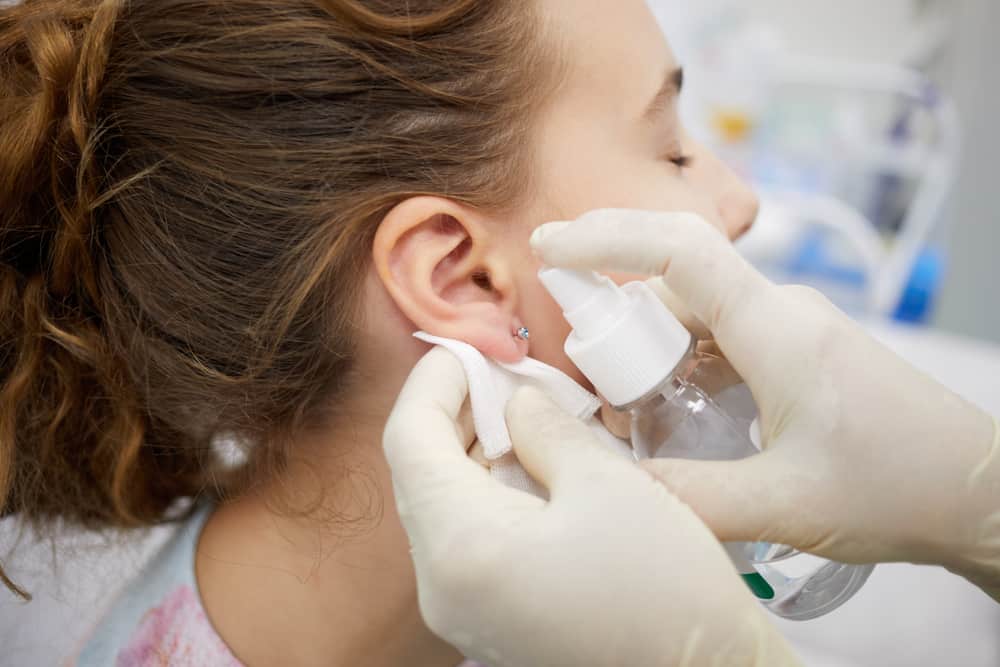 Doctor sterilize piercing place on ear